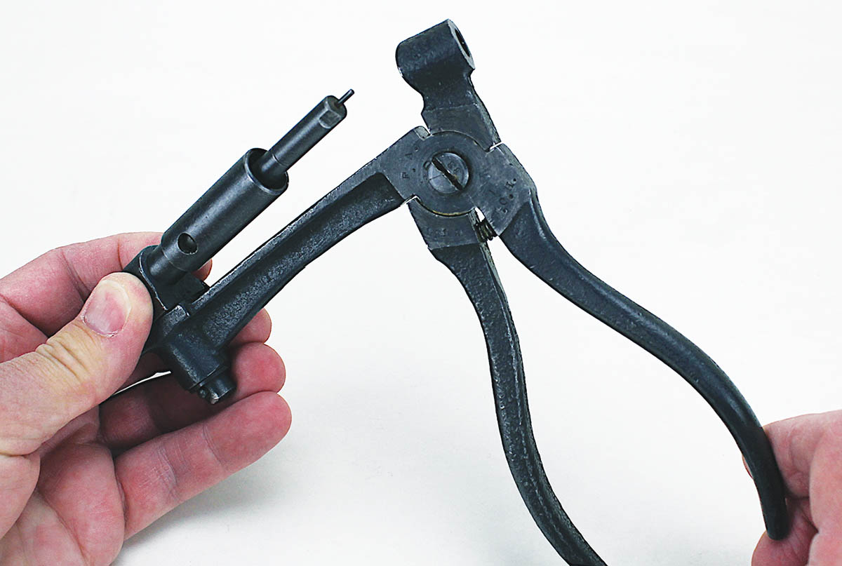 To deprime, insert the spindle with the proper cap into the tool, place a fired case over the spindle, squeeze the handles and the primer pops out.